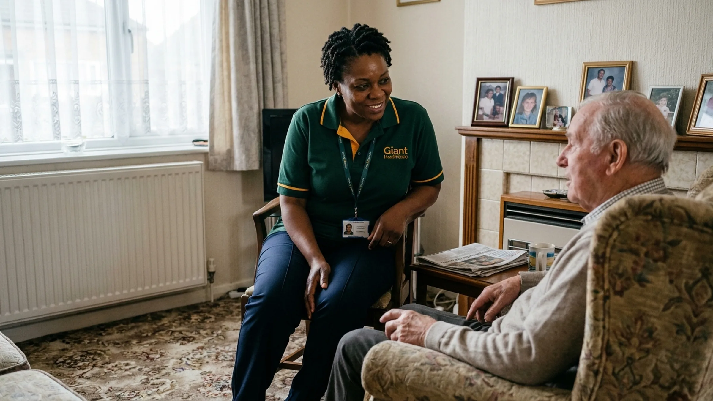 A Giant Healthcare carer sitting and listening to an older man in the front room of his Corby home.